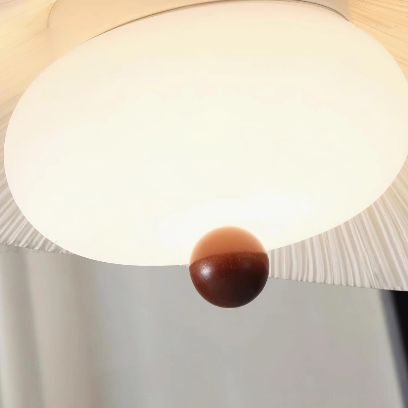 Serafina pendant light detail close-up bottom view showing frosted glass diffuser wooden finial brass accents and pleated fabric trim