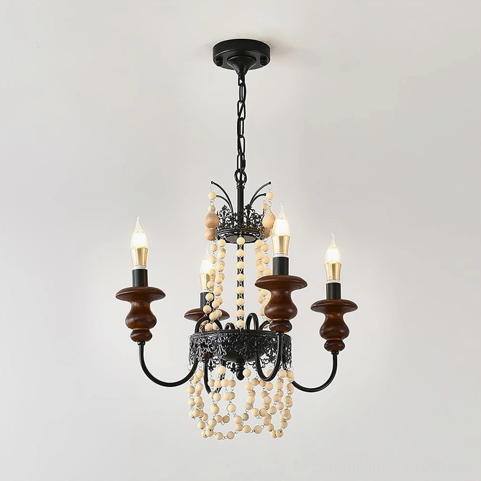 Four-head compact Seraphine rustic chandelier with visible candle arms and beaded drapes detail shot from left three-quarter angle