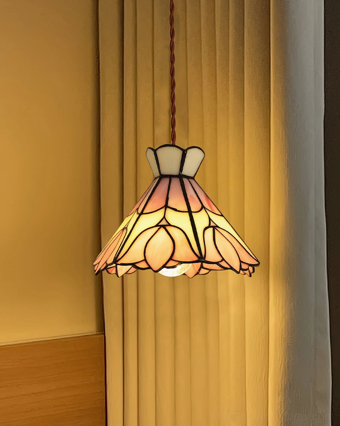 Serena Tiffany-style pendant light installed in warm home interior with yellow curtains, glowing stained glass shade