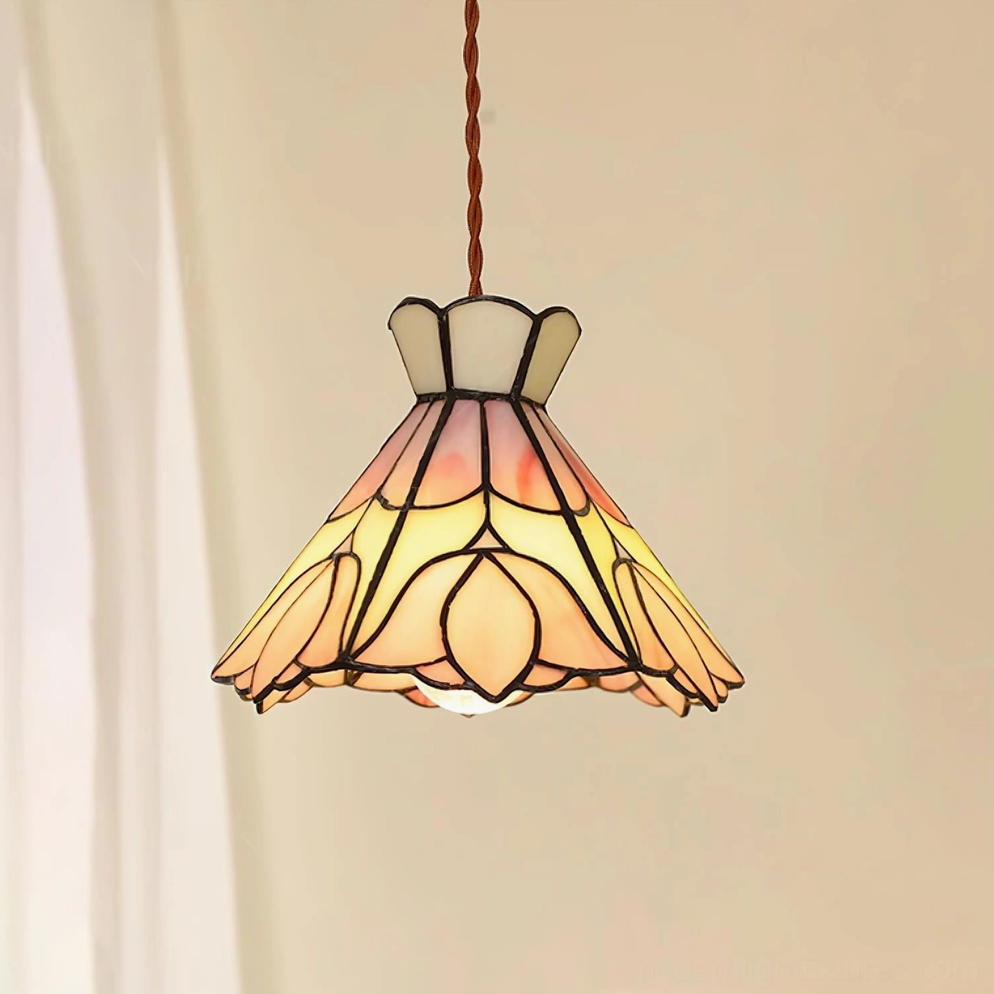Serena pink stained glass pendant light close-up with warm illumination showing rose-tinted glow and metal frame