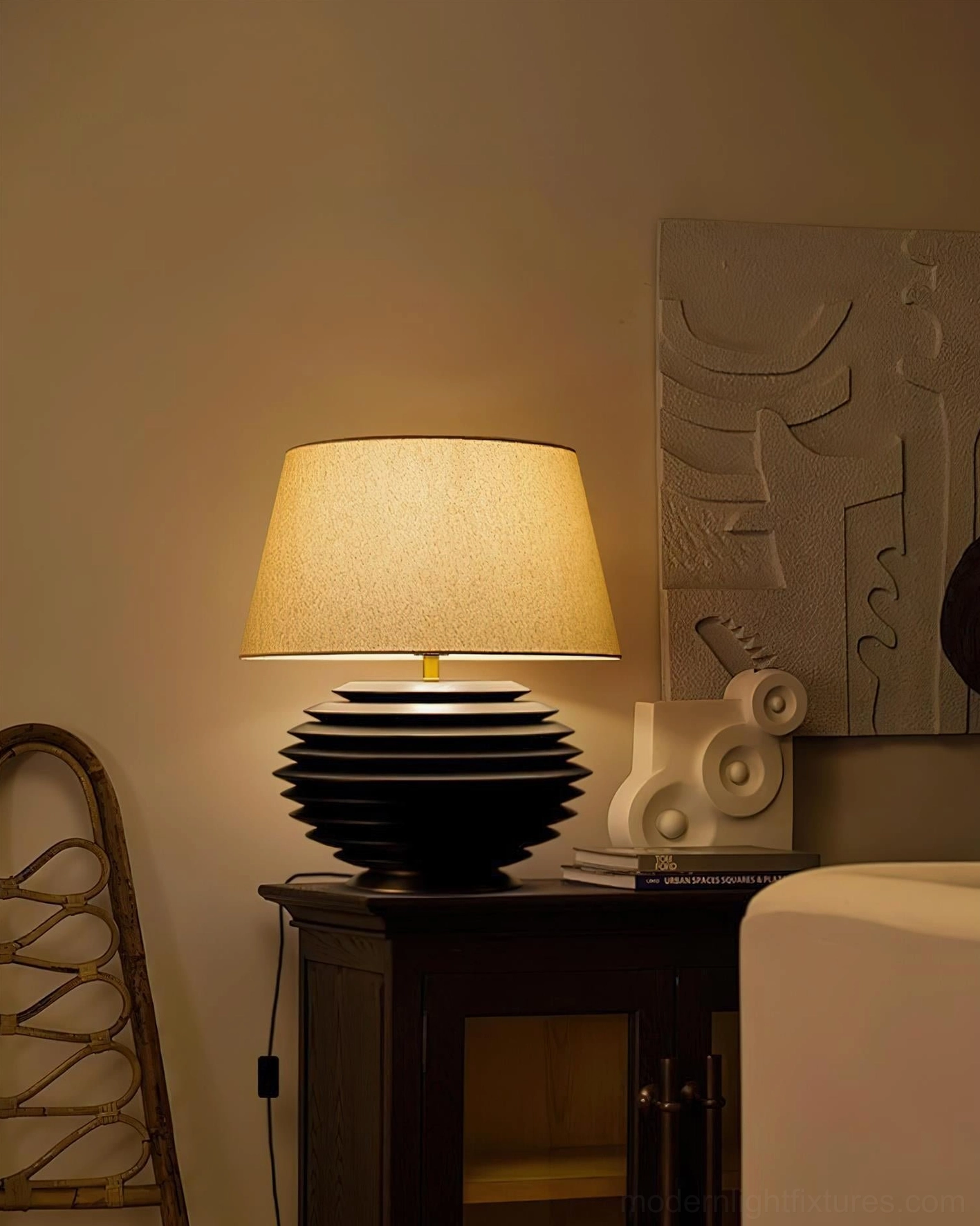 Serenity Strata table lamp side view in minimalist living room with lit beige shade, paired with contemporary home decor on side cabinet