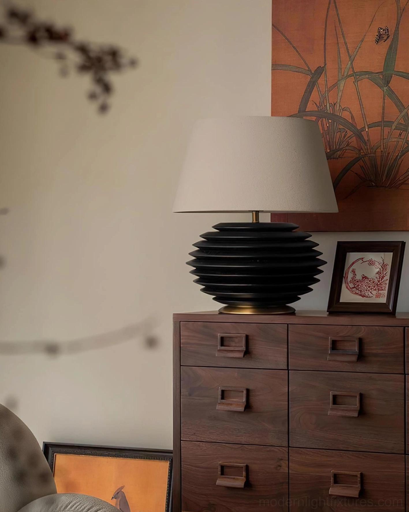 Serenity Strata table lamp three-quarter front view displayed on vintage study side table with dark wood dresser, warm ambient lighting from beige fabric shade