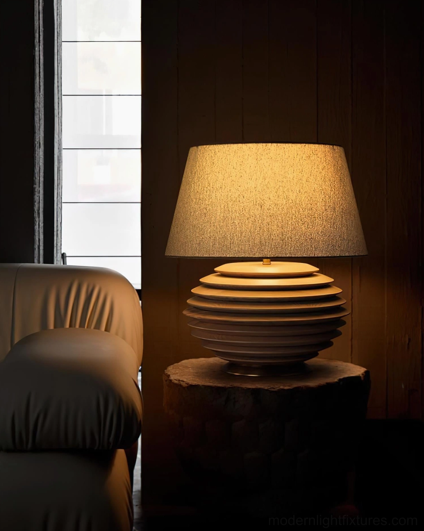 Serenity Strata table lamp brown-toned ribbed base on natural wood stump side table, three-quarter front view in rustic warm living room