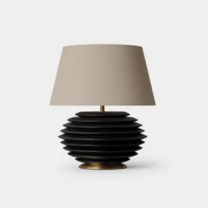 Serenity Strata table lamp with black ribbed ceramic base and beige tapered cotton-linen fabric shade on white studio background, modern minimalist design