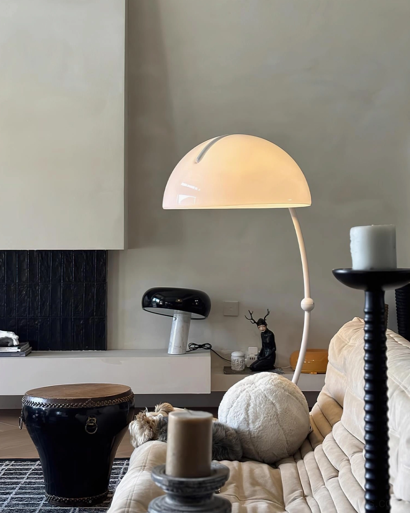 Serpente articulated floor lamp casting light in contemporary bedroom setting with minimal décor