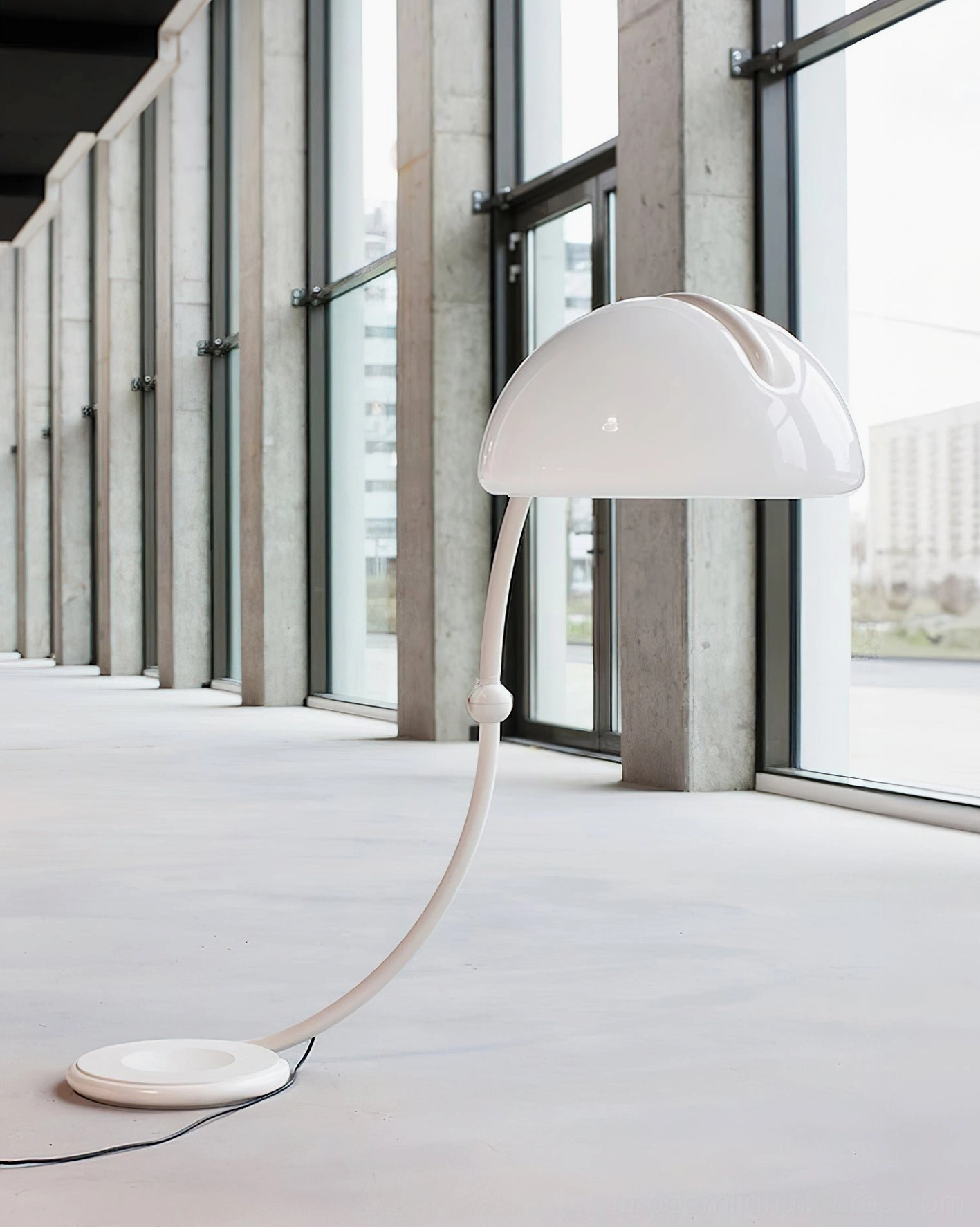 White Serpente rotating floor lamp in modern apartment with floor-to-ceiling windows