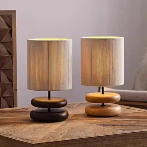 Two wooden table lamps in matching styles with different wood finishes displayed on side table