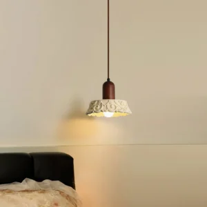 Vintage carved resin pendant light installed in bedroom with black leather bed, warm ambient lighting side angle view