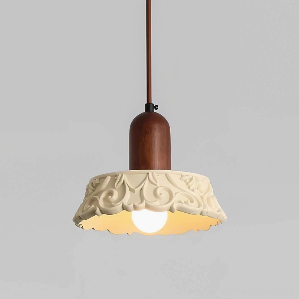 Shana pendant lamp front overhead studio view showcasing carved floral pattern detail with exposed warm bulb glow