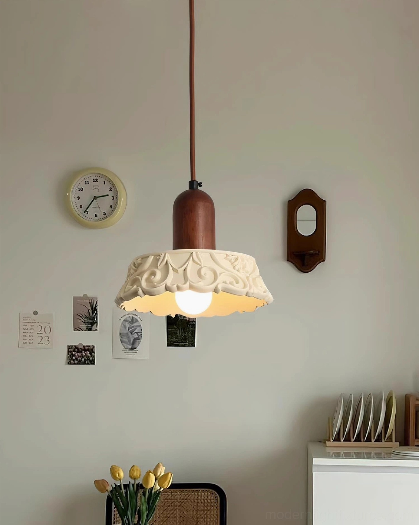 Shana pendant light fixture displayed in bedroom interior with wall clock and decorative elements, three-quarter side view