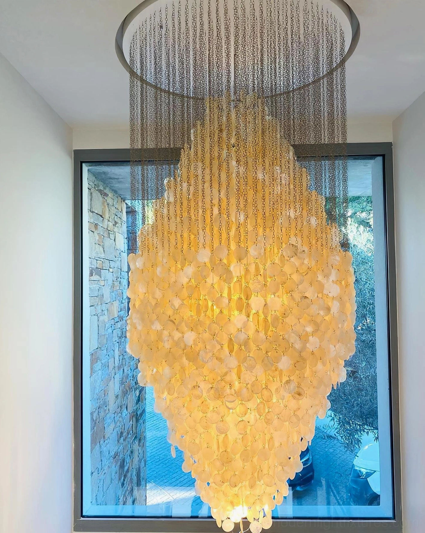 Minimalist white shell chandelier in contemporary bedroom setting with neutral palette and soft illumination