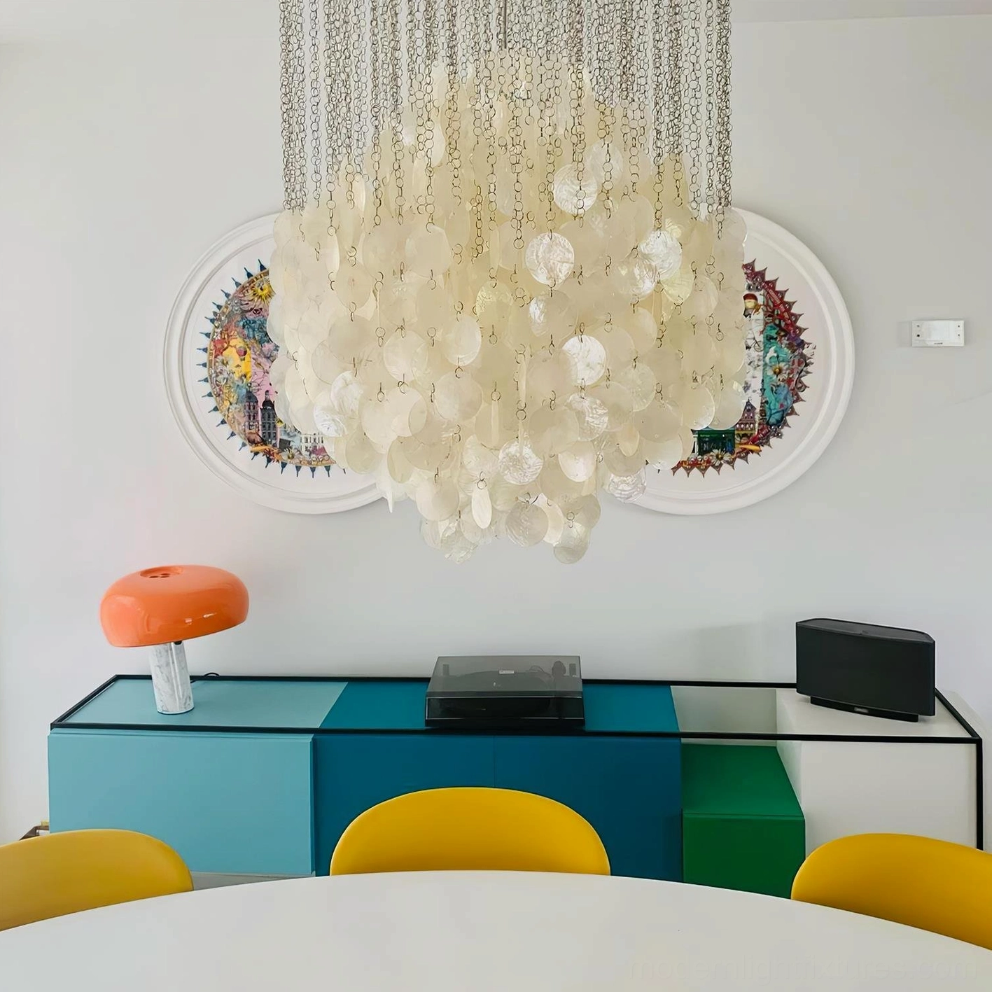 Beige capiz shell chandelier with warm illumination in modern dining area with metal suspension and luxury lighting