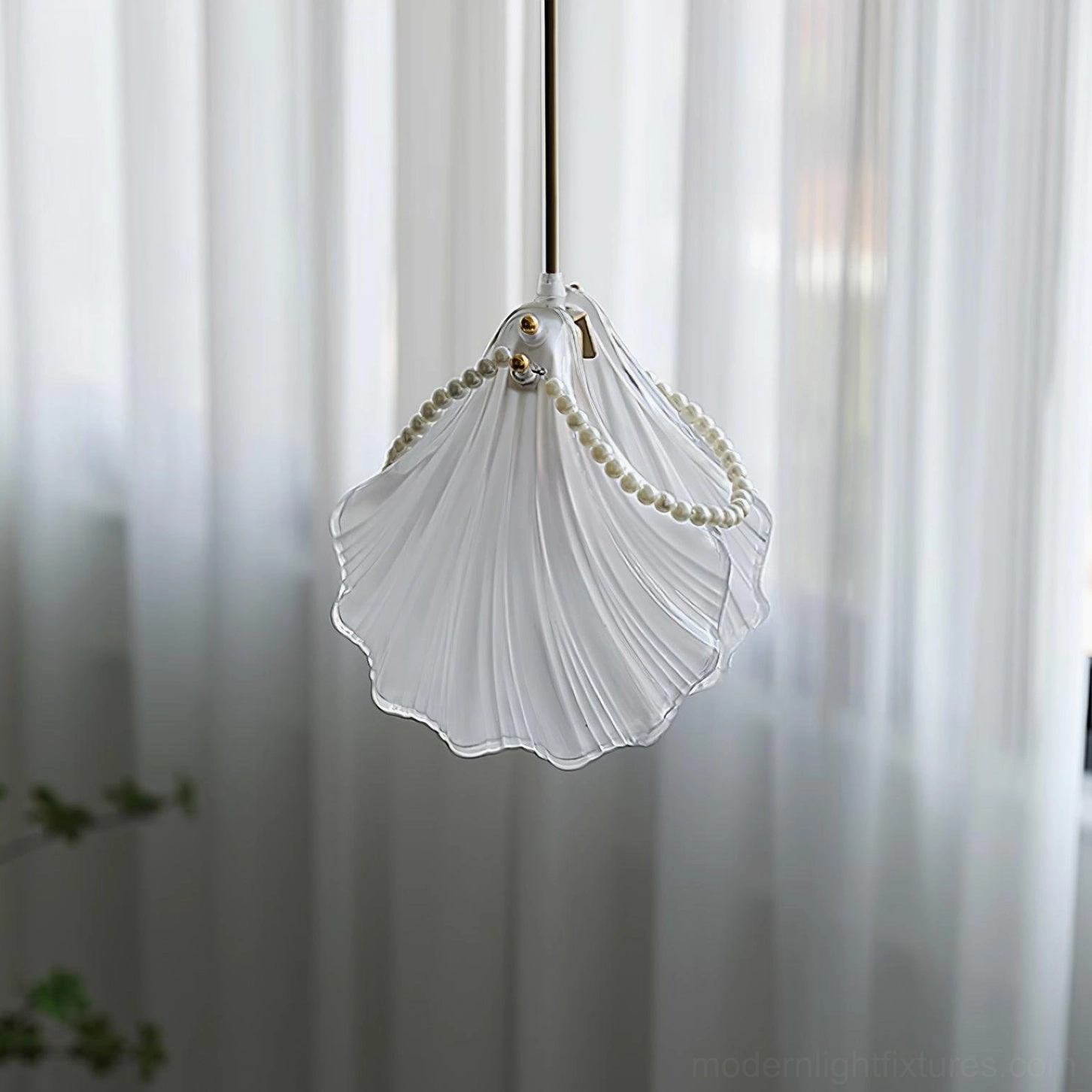 Shell pendant lamp with ruffled frosted glass creating soft diffused lighting effect