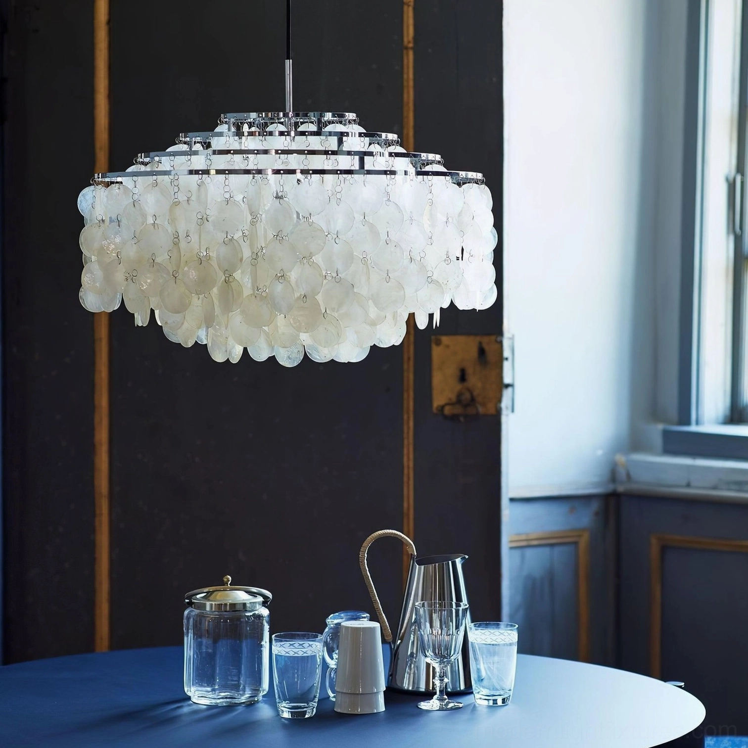 Shell pendant chandelier linear arrangement over extended dining table installation