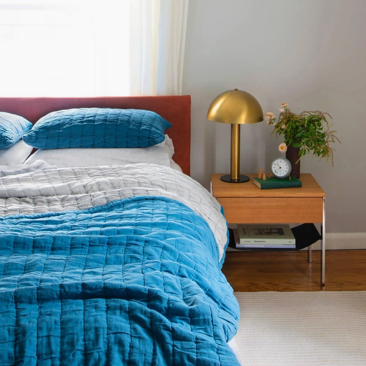 Gold brass mushroom lamp in master bedroom scene with blue quilted bedding and home decor