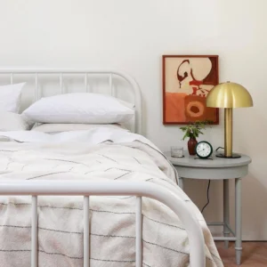 Brushed copper mushroom table lamp on bedroom nightstand next to bed - warm metallic finish