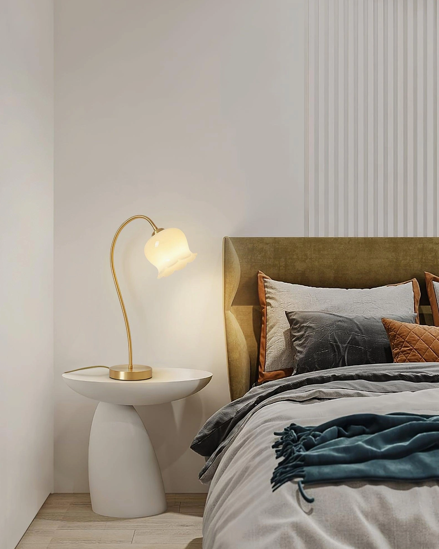 Brass lily flower table lamp on organic-shaped bedside table in contemporary bedroom, ambient warm lighting