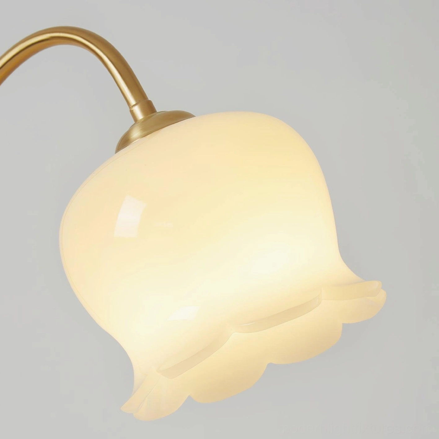 Siena modern brass table lamp displaying warm ambient lighting quality, milky white shade with brass frame