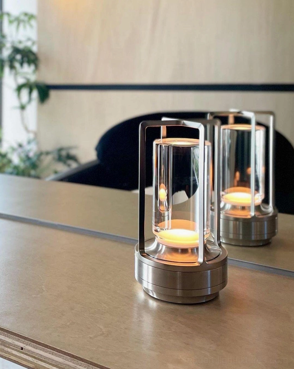 Pair of silver cordless LED table lamps on modern home dining table, front flat view with dual lit fixtures