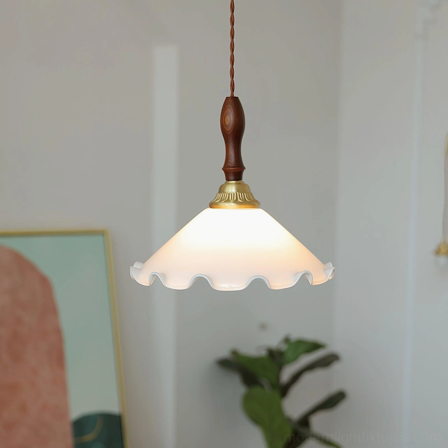 Simple frilled pendant light with milk-white frosted shade and wood-brass hardware, studio view