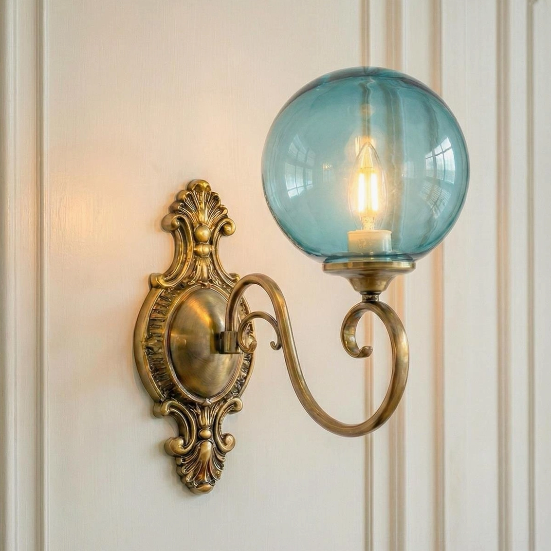 Single-head ornate brass wall sconce with blue glass globe, classic baroque backplate vintage design