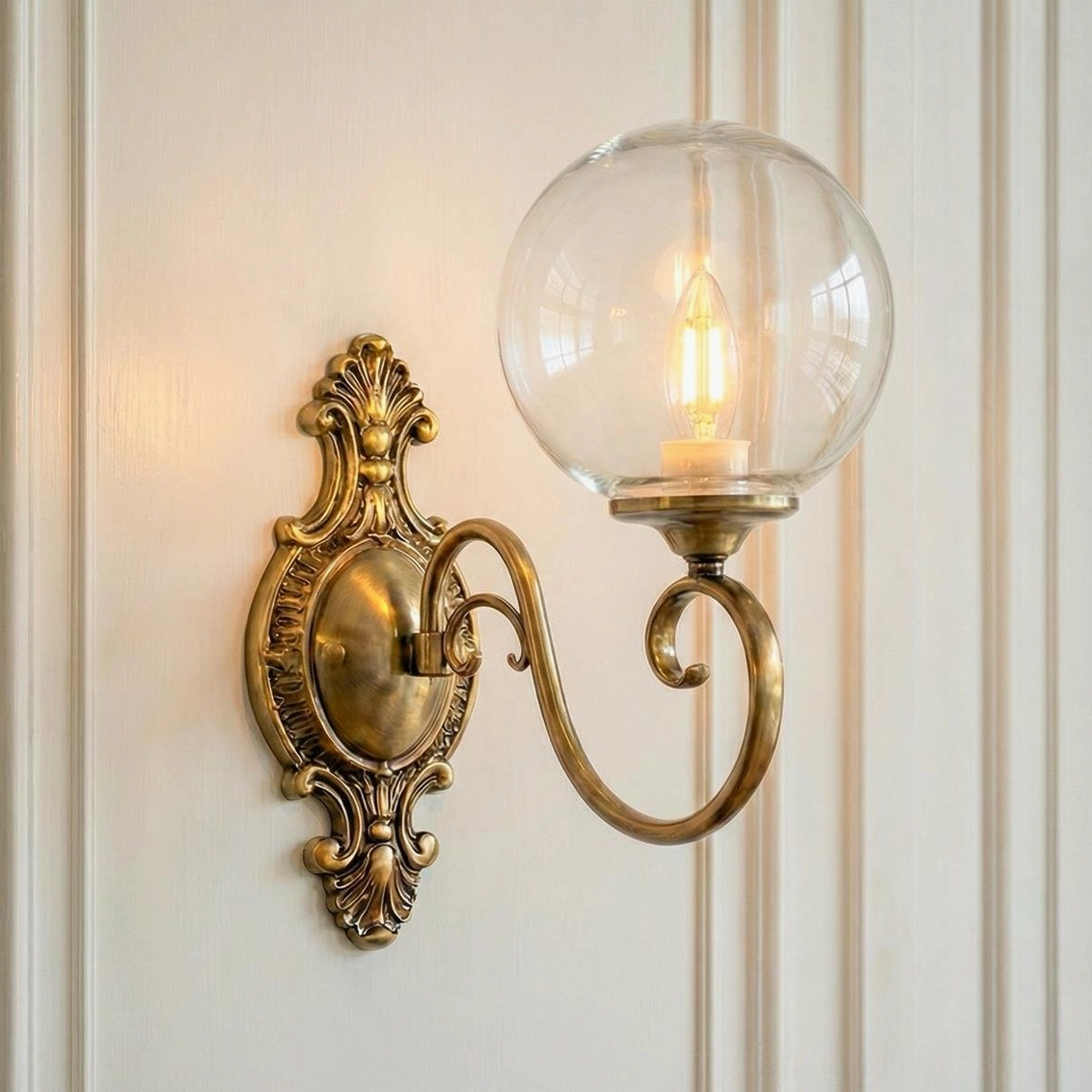 Single-head ornate brass wall sconce with clear glass globe, vintage baroque backplate lamp