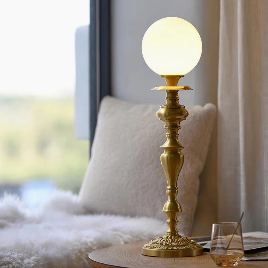 Single-head brass table lamp with frosted glass shade on designer nightstand or side table