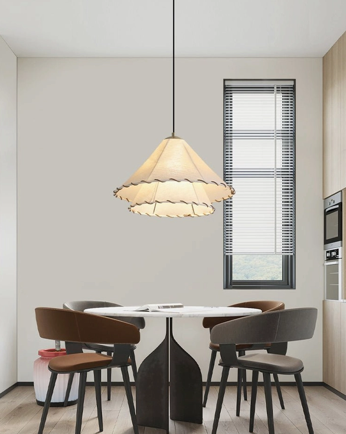 Single handmade ruffled pendant light in compact dining nook with soft warm ambient glow and wabi-sabi style