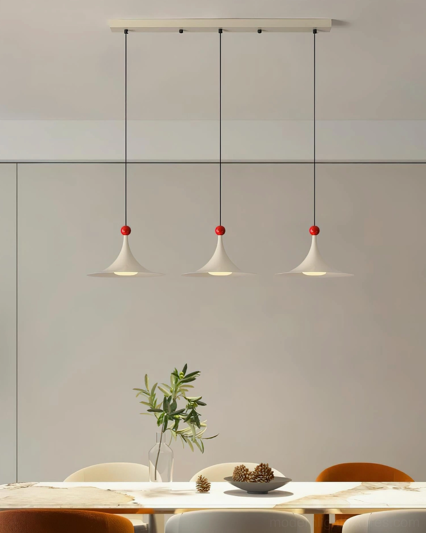 Sirocco triple-head cream pendant light with red sphere accents in modern dining room, eye-level view