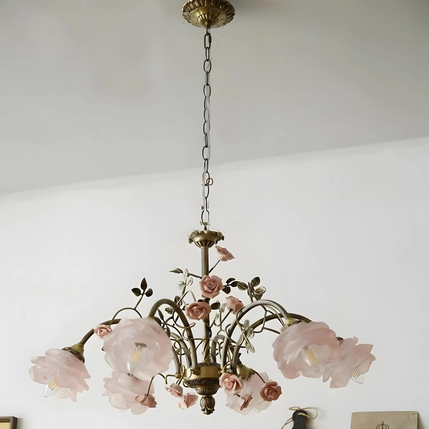 Six head blush pink floral chandelier with antique brass frame showcasing delicate rose vine botanical detailing and translucent glass shades