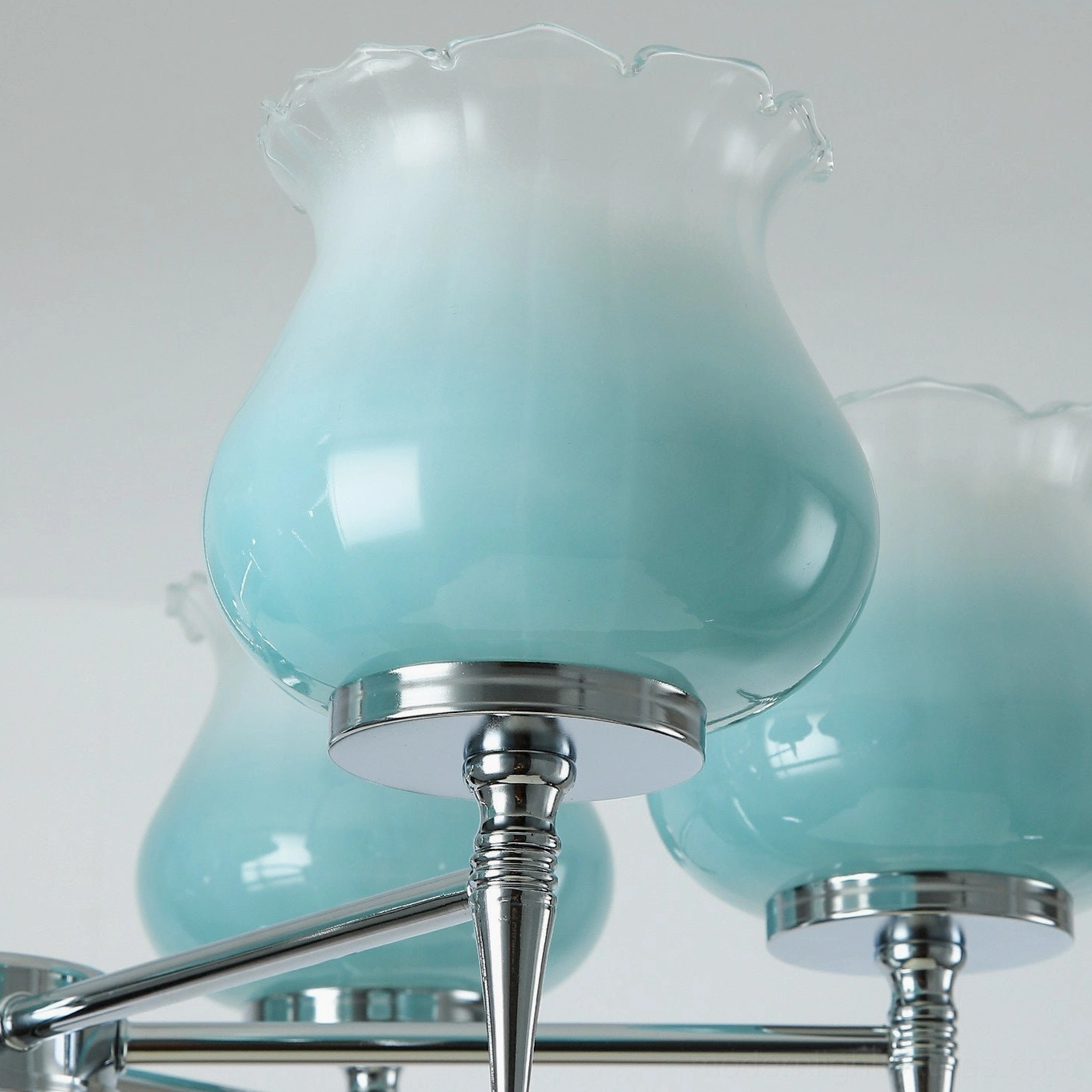 Skylin 8-arm full spread chrome chandelier installation shown over large dining table with extended light coverage