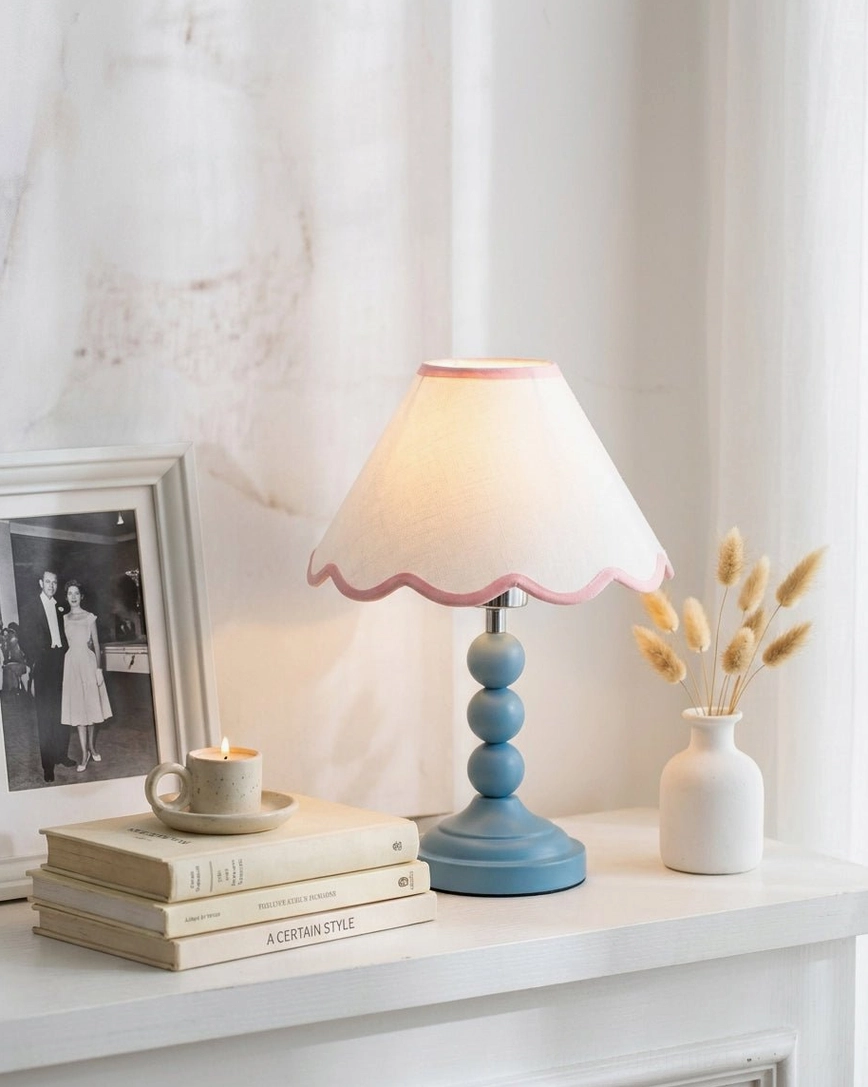 Skylisse table lamp displayed on fireplace mantel shelf styled with stacked books, framed photo and dried flower arrangement