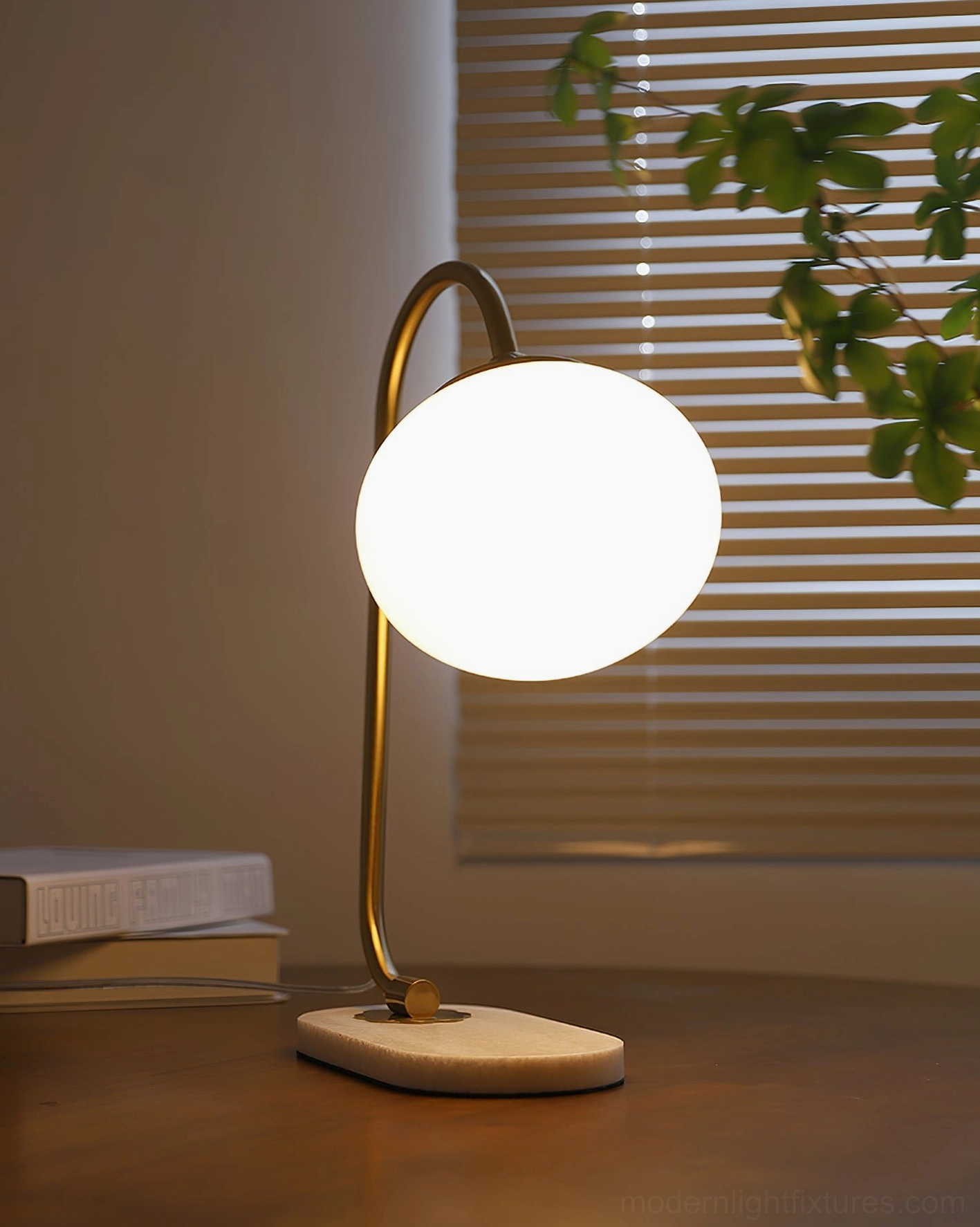 Sleek globe table lamp design with minimalist curved metal arm and spherical glass shade