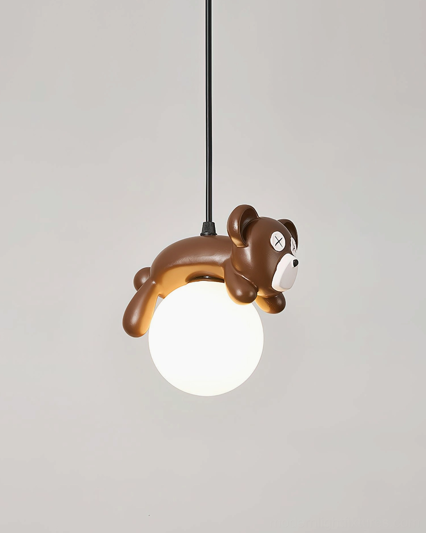 Glowing frosted glass bear pendant lamp with black suspension cable, neutral gray studio background