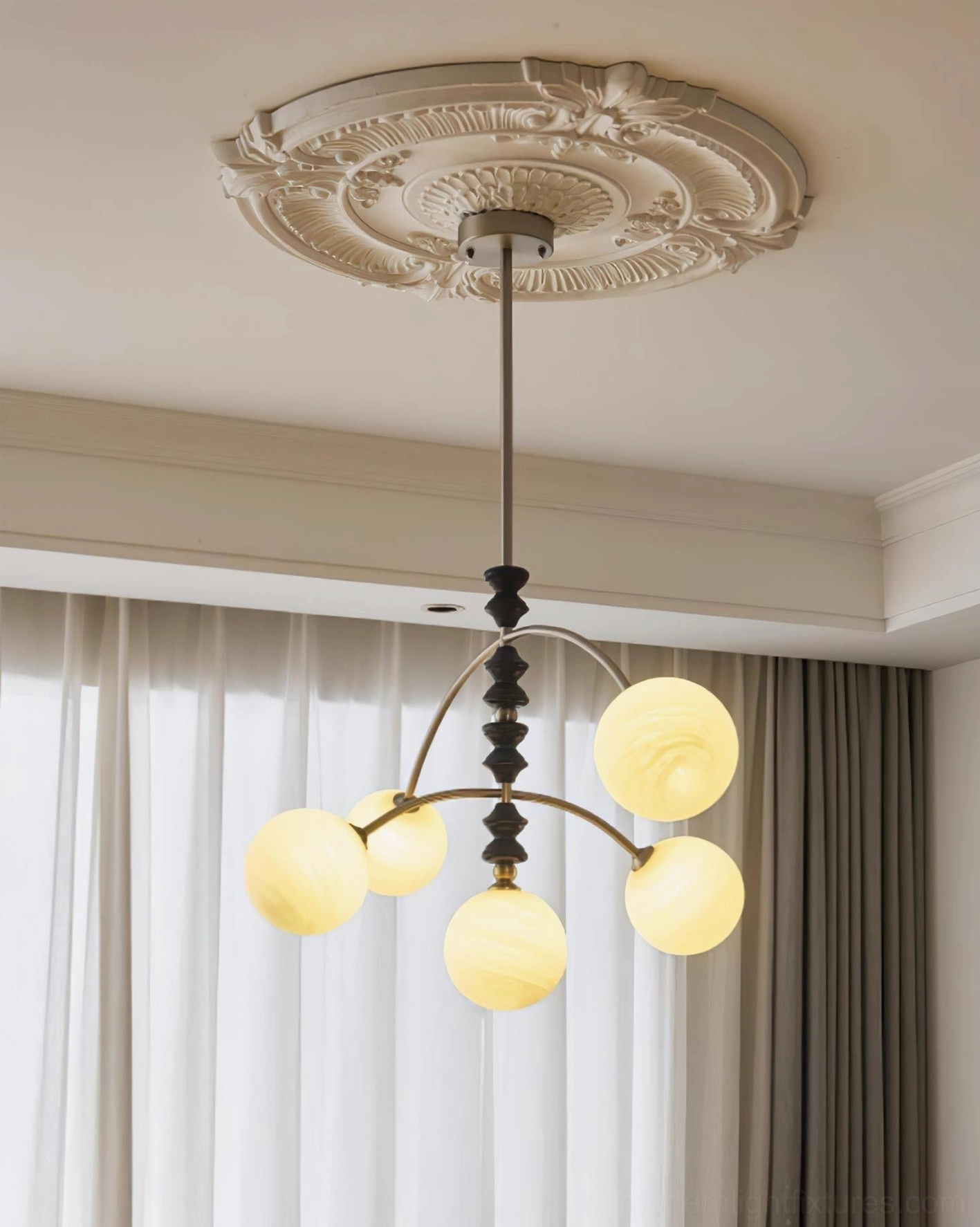Arc chandelier with brass accents and frosted glass globe shades showing warm illumination
