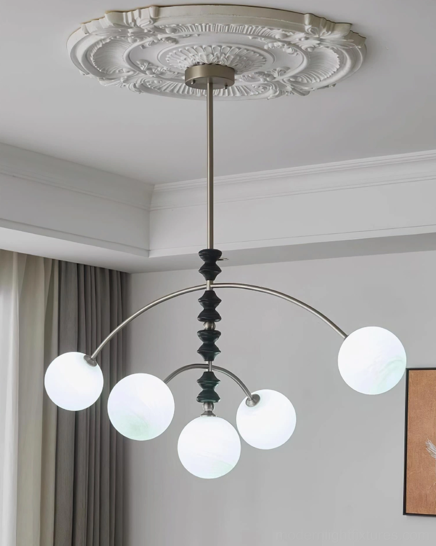 Multi-globe arc chandelier with cool white glass shades installed in living room with ceiling medallion