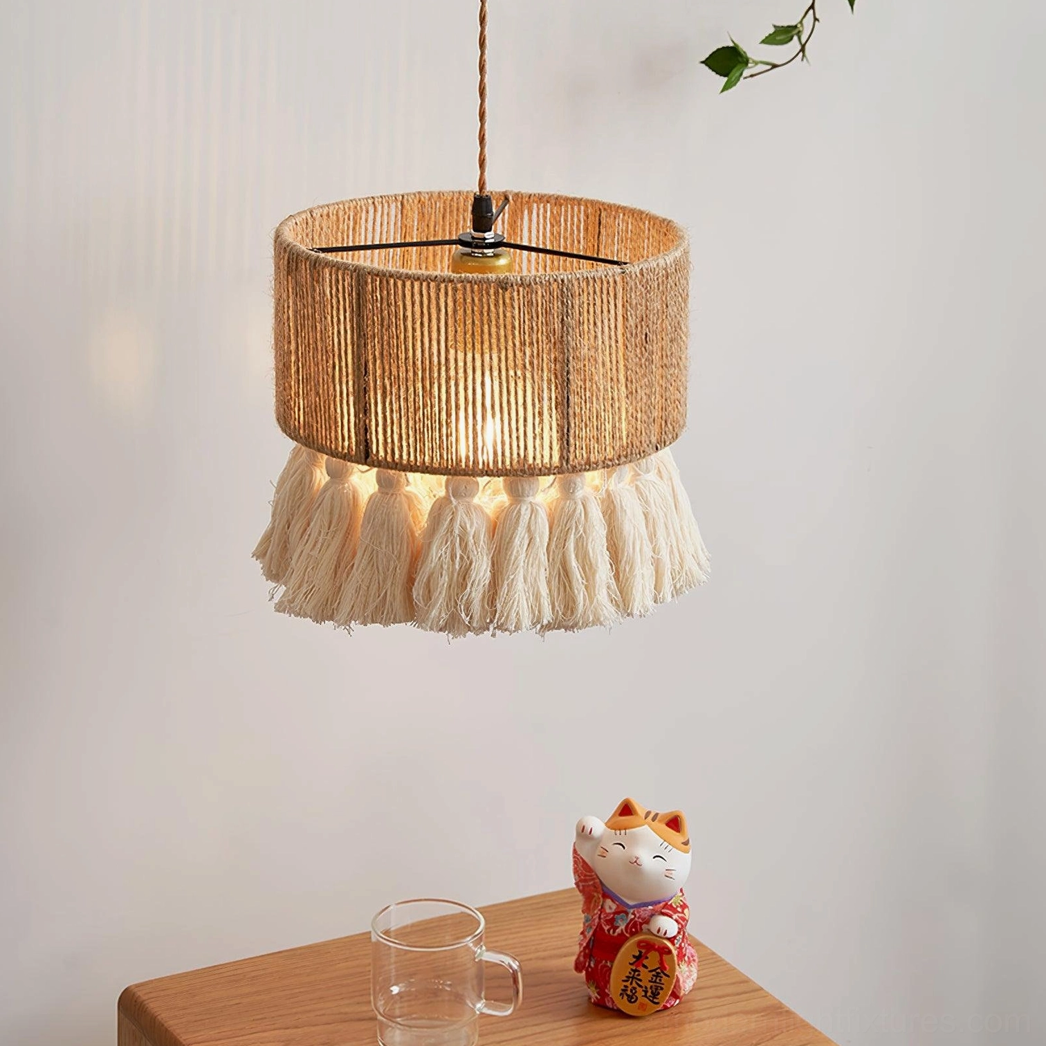 Small drum tassel pendant light with woven rattan shade, side view with ambient warm lighting