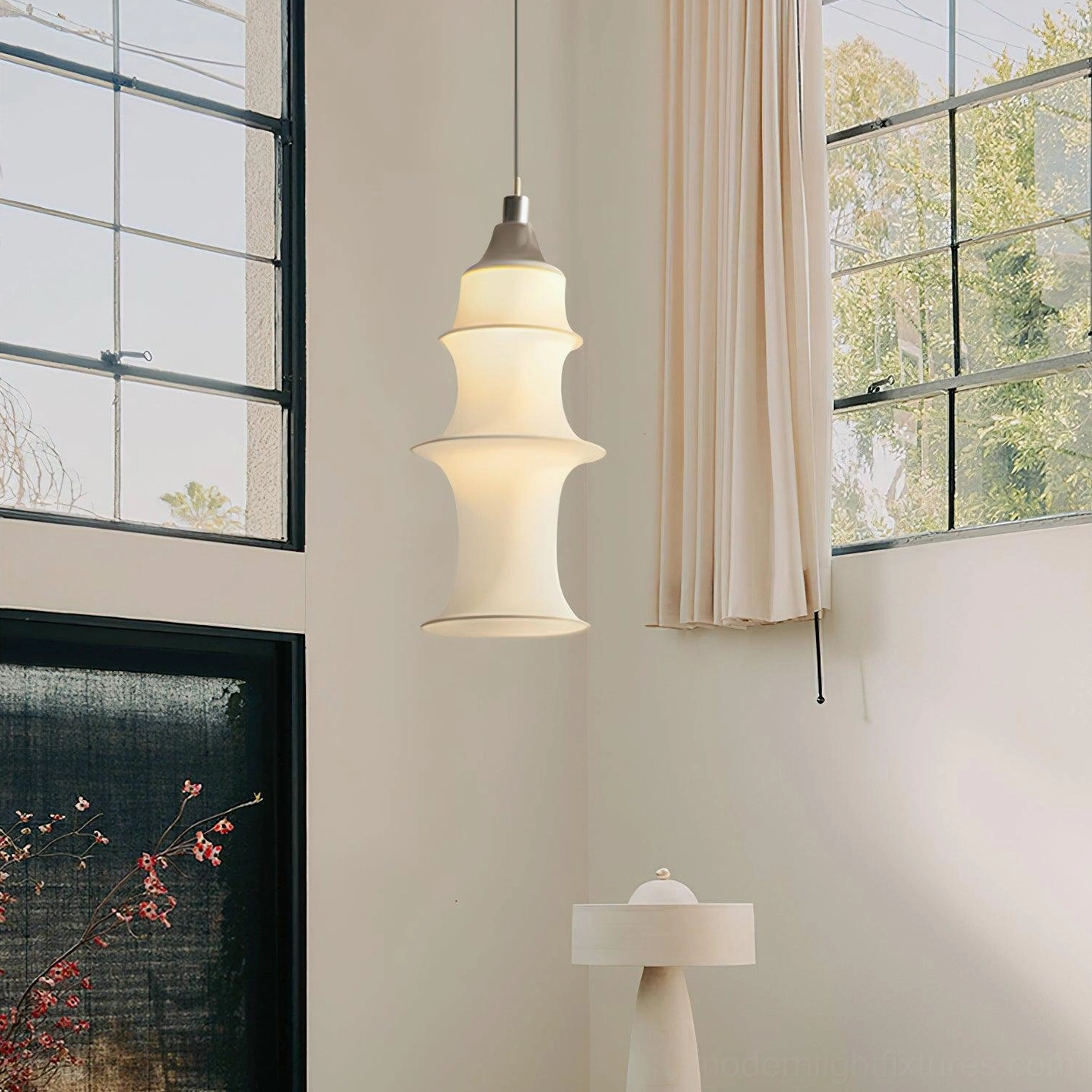 Small modern tiered white fabric pendant lamp in minimalist residential corner with warm glow