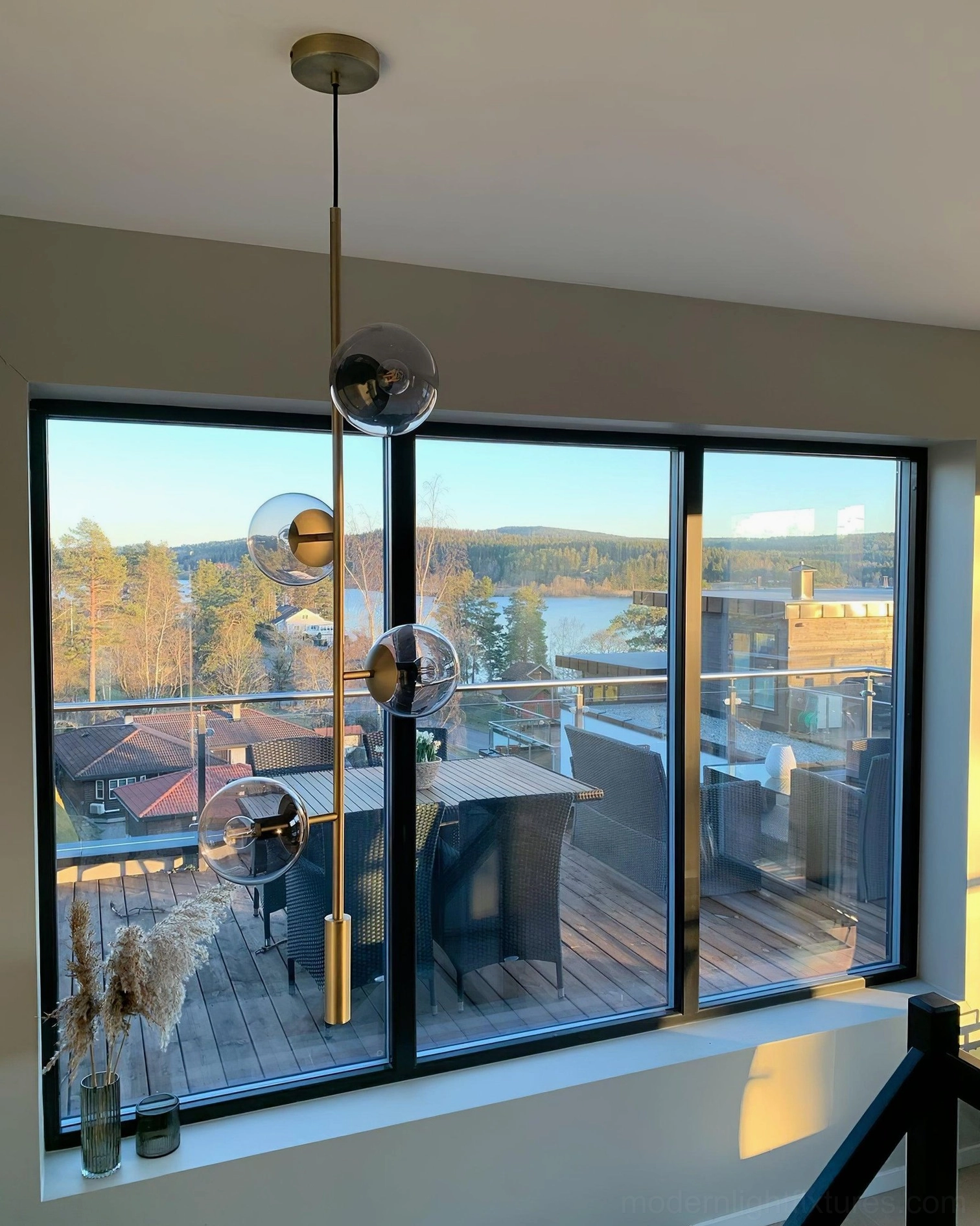 Glass orb chandelier with smoked gray glass spheres by apartment window, natural light interaction