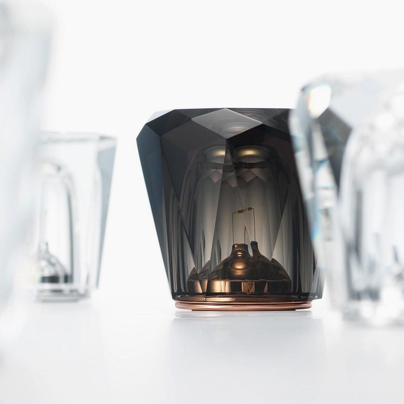 Smoky crystal diamond table lamp with rose gold metal base on white marble surface, side view showing polygonal facet geometry and internal LED structure