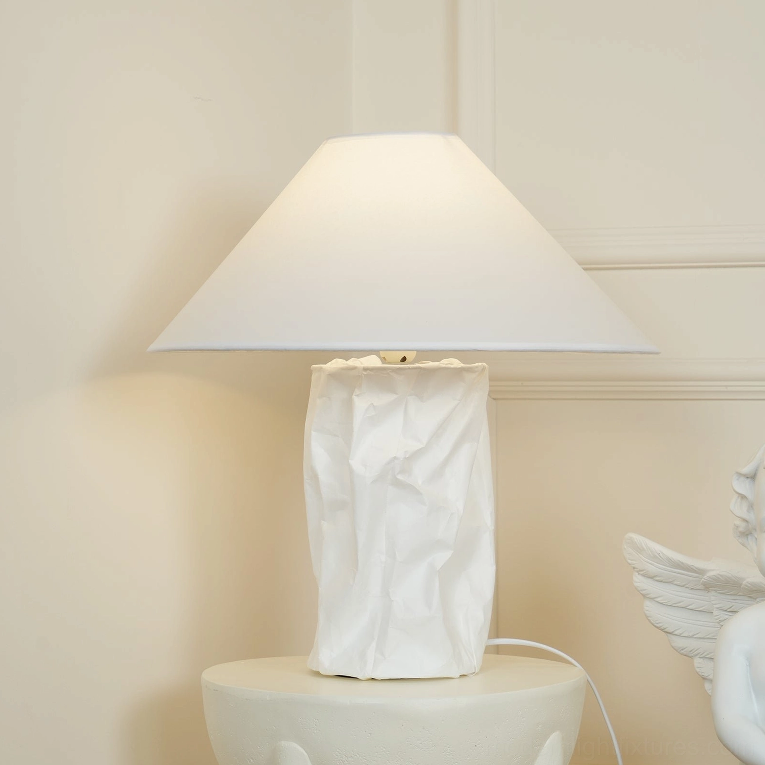 Artisan table lamp with crinkled shade providing soft diffused light in bedroom