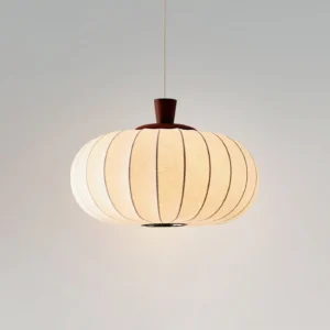 Illuminated beige fabric Softon pendant light casting warm diffused glow - eye-level front view with studio lighting