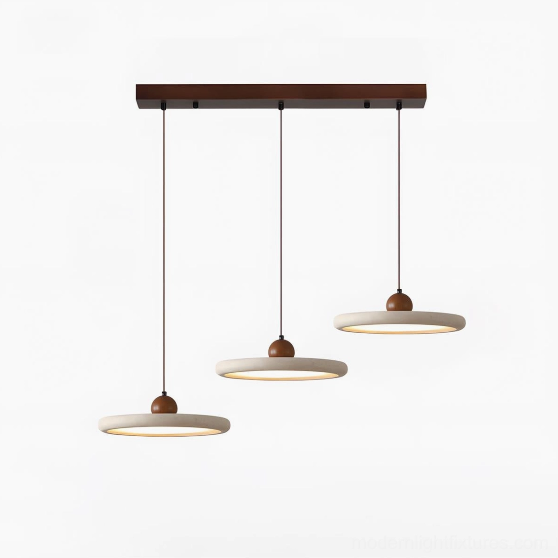 Three-head travertine pendant light set creating dramatic linear lighting above extended kitchen island