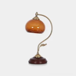 Solenne mid-century modern table lamp with curved metal arm, handblown amber glass shade, and sculptural wooden base on white background