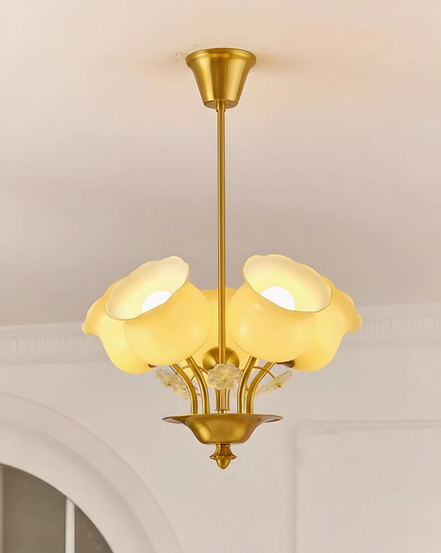 Solenne Petal Chandelier brass metal frame with frosted glass details in French-style arched ceiling room