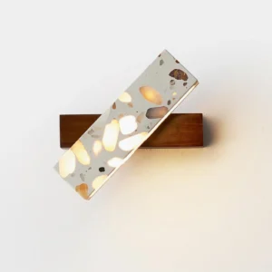 Soltera modern wall sconce illuminated close-up showing warm 3000K LED lighting and terrazzo texture detail