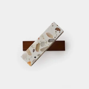 Soltera terrazzo wall sconce flat lay top view showing modern sculptural design with dark wooden base