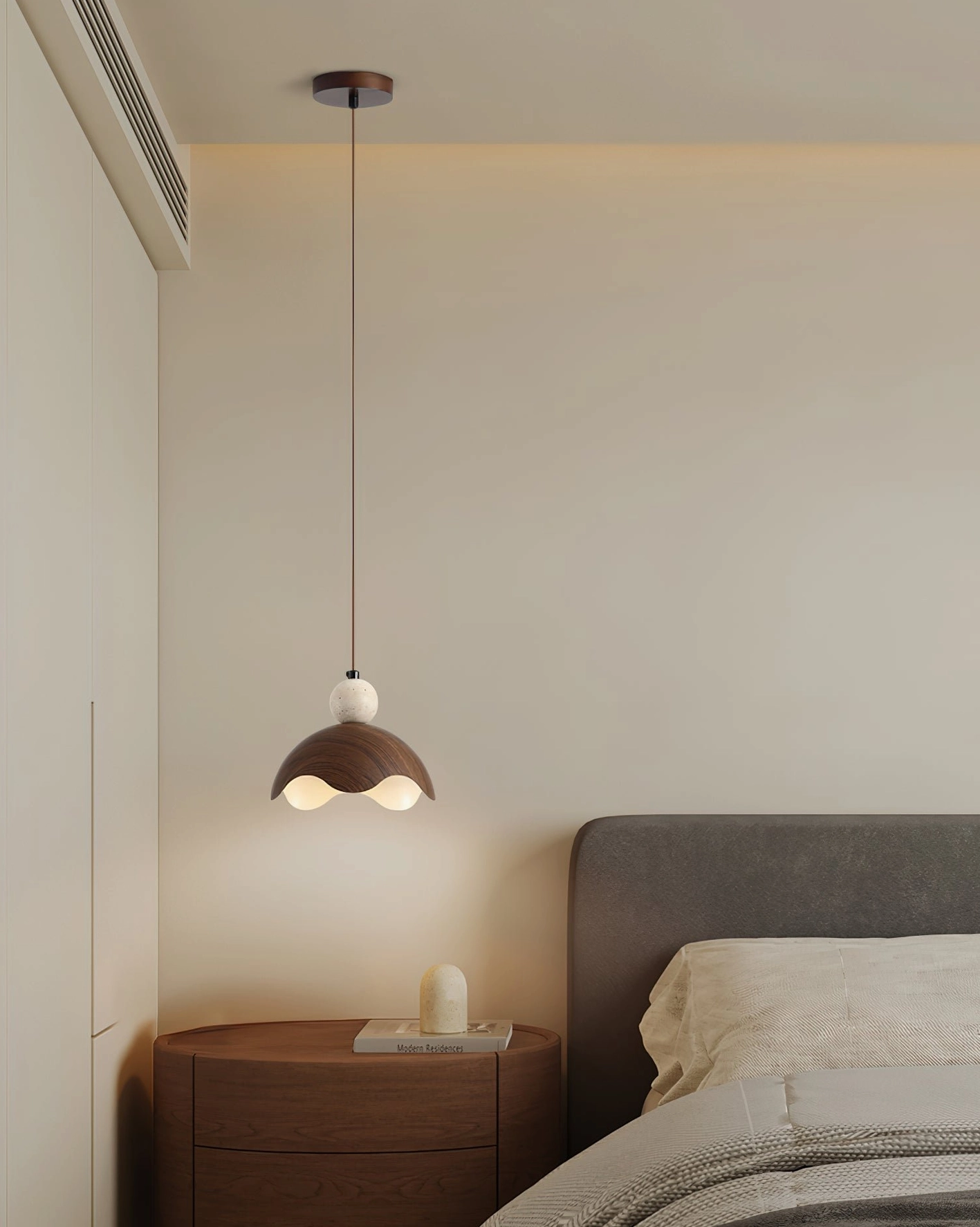 Somira modern bedside pendant light, side view showing walnut metal shade with soft glow in neutral bedroom interior