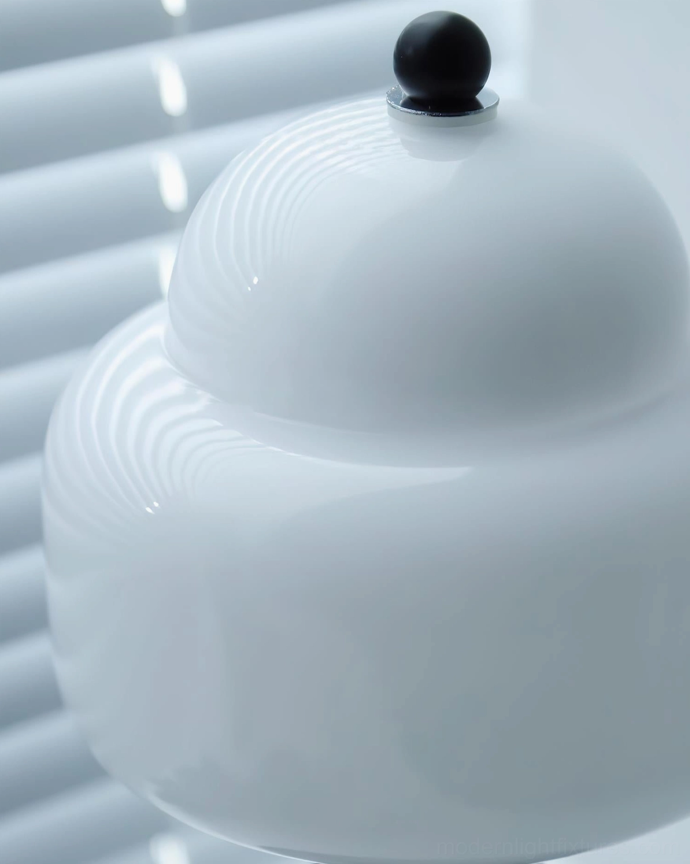 Close-up overhead view of Soreli table lamp frosted glass shade with smooth tiered finish and black finial