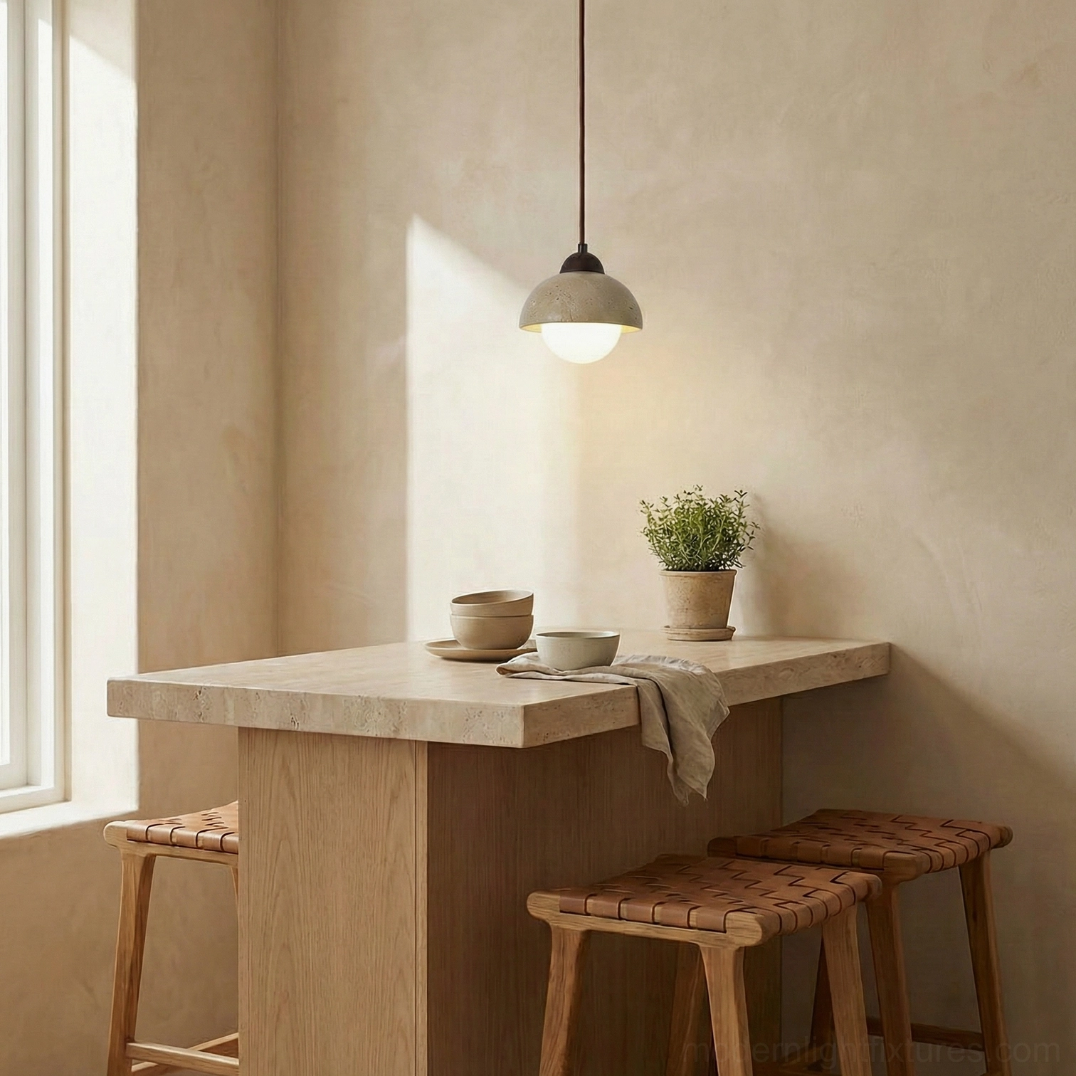 Soren travertine pendant light suspended over small dining nook with wooden furniture warm glow